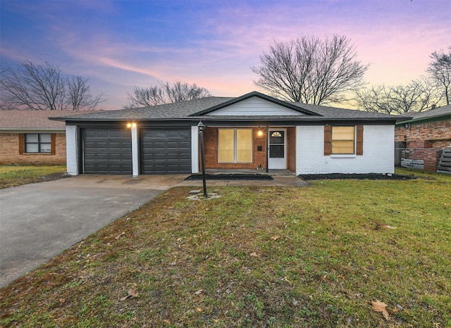 single story home featuring a garage and a front lawn