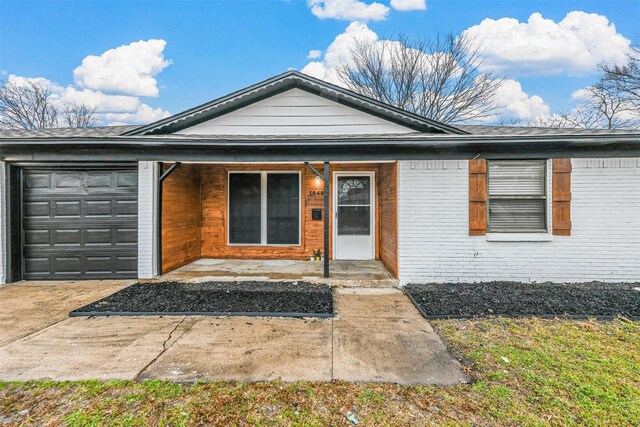 ranch-style home with a garage, a front yard, and covered porch