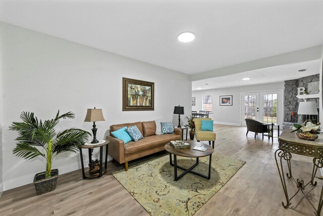 living area with a textured ceiling and light hardwood / wood-style flooring