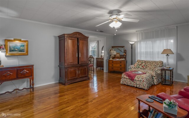 living room featuring light hardwood / wood-style floors, crown molding, and ceiling fan