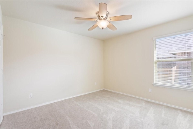 empty room featuring ceiling fan and light colored carpet