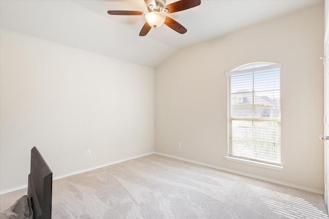 spare room with ceiling fan, light colored carpet, and lofted ceiling