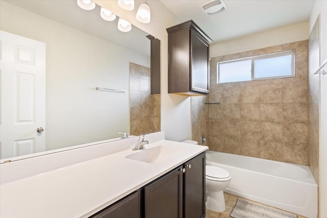 full bathroom with toilet, tile patterned flooring, tiled shower / bath, and vanity