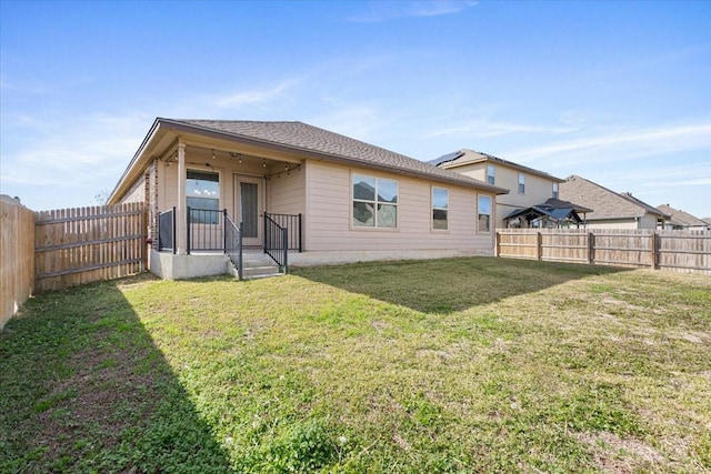 rear view of property featuring a lawn