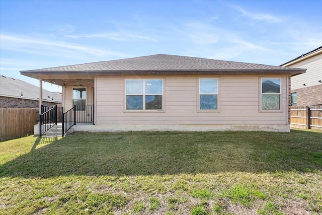 rear view of property featuring a lawn