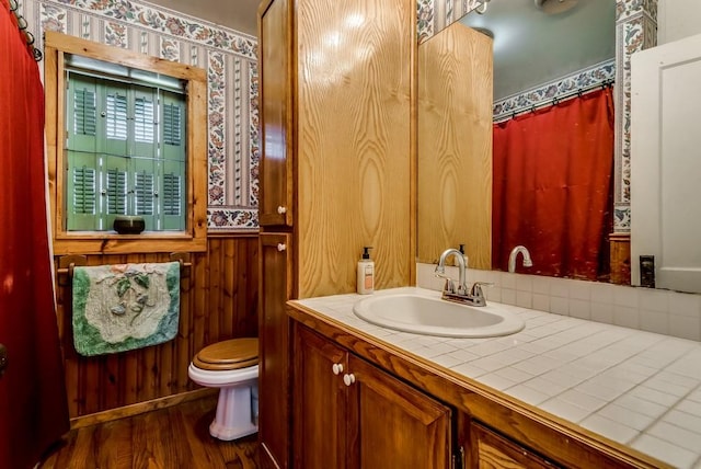 bathroom featuring wood-type flooring, toilet, and vanity