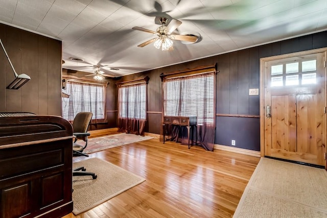 home office with ceiling fan, a wealth of natural light, and light hardwood / wood-style floors