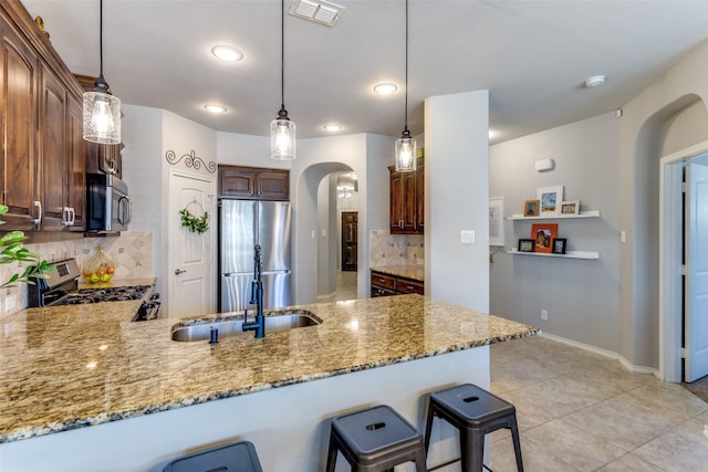 kitchen featuring decorative light fixtures, stainless steel appliances, and tasteful backsplash