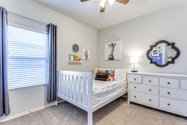 bedroom featuring ceiling fan, light colored carpet, and multiple windows