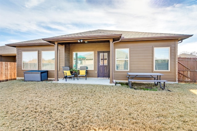 rear view of property with a lawn and a patio