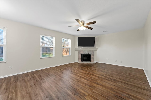 unfurnished living room with ceiling fan, dark hardwood / wood-style floors, and a brick fireplace