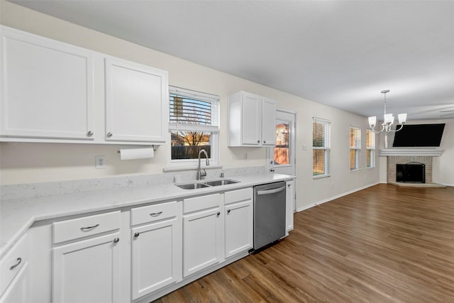 kitchen featuring white cabinetry, a brick fireplace, dark wood-type flooring, dishwasher, and sink