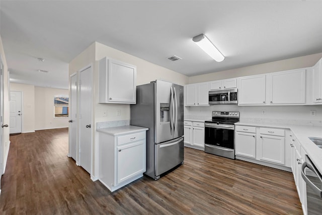 kitchen with white cabinets, dark hardwood / wood-style flooring, and stainless steel appliances