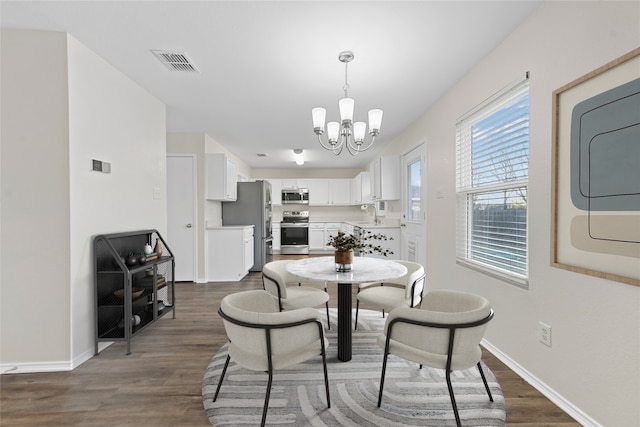 dining area with a chandelier, dark hardwood / wood-style flooring, and washer / clothes dryer