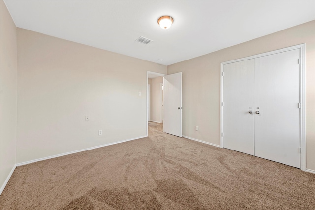 unfurnished bedroom featuring carpet and a closet