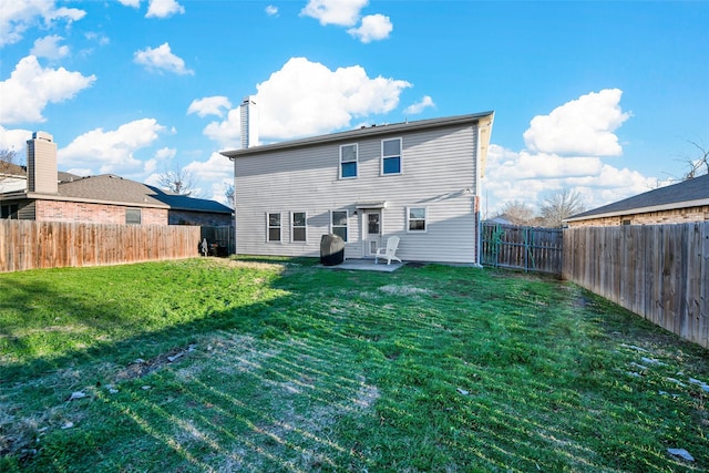 back of house with a patio area and a yard