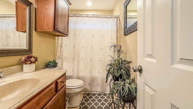 bathroom featuring toilet, vanity, and curtained shower