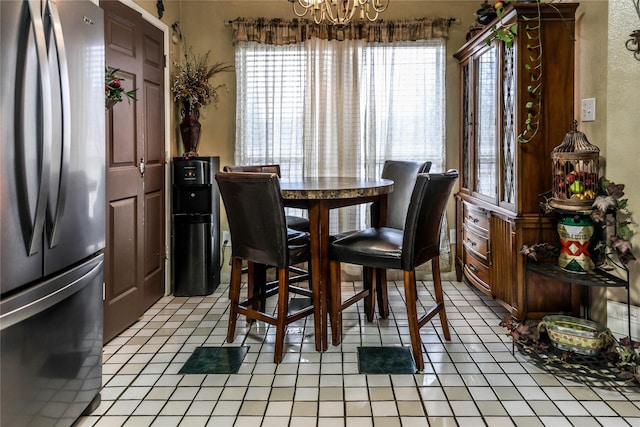 dining area with light tile patterned floors and a notable chandelier