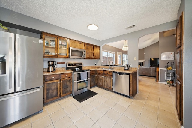 kitchen featuring light tile patterned floors, light stone countertops, sink, and stainless steel appliances