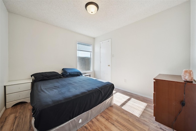 bedroom featuring hardwood / wood-style floors and a textured ceiling