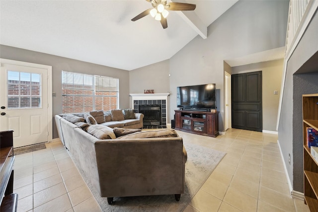 living room featuring ceiling fan, lofted ceiling with beams, a fireplace, and light tile patterned flooring