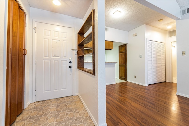 hall featuring wood-type flooring and a textured ceiling