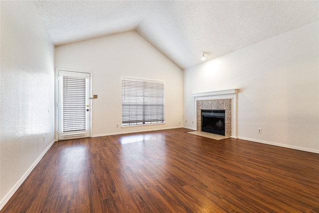 unfurnished living room with lofted ceiling, a fireplace, a textured ceiling, and dark hardwood / wood-style floors