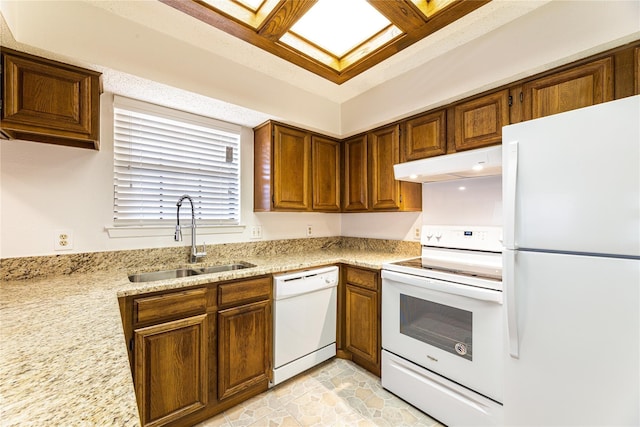 kitchen featuring light stone countertops, sink, and white appliances