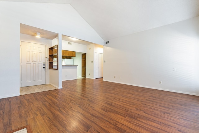 unfurnished living room featuring high vaulted ceiling and dark hardwood / wood-style floors