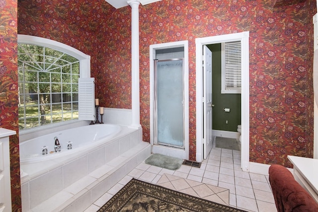 bathroom with tile patterned flooring, a stall shower, a bath, toilet, and baseboards
