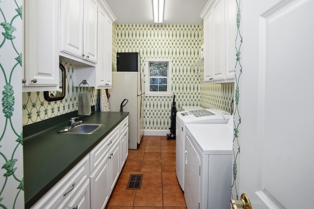clothes washing area with washer and dryer, cabinet space, and tile patterned flooring