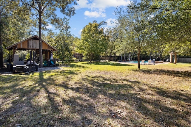 view of yard with an outdoor pool and view of scattered trees