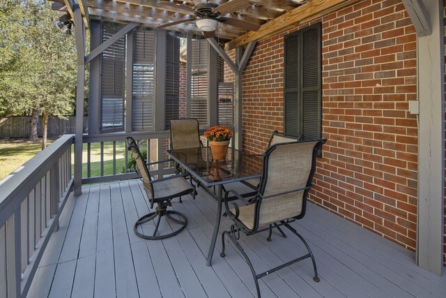 wooden deck featuring a ceiling fan, outdoor dining space, and fence