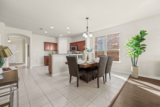 dining space with sink, an inviting chandelier, and light tile patterned floors