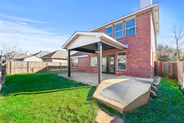 rear view of house with a patio area and a lawn