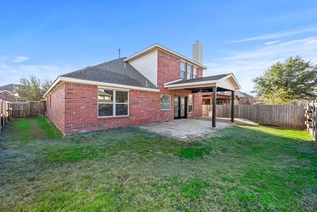 rear view of house with a patio area and a lawn