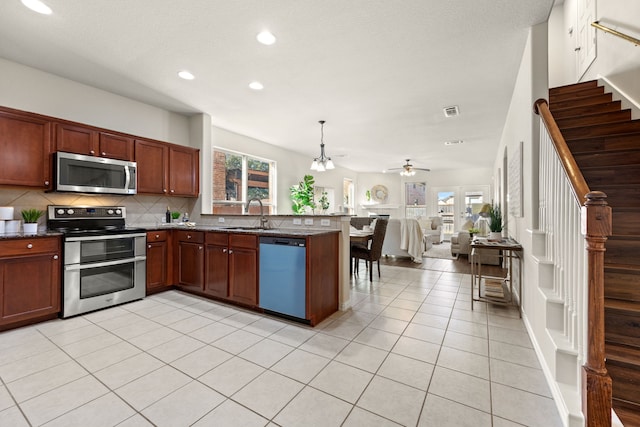 kitchen featuring pendant lighting, stainless steel appliances, tasteful backsplash, ceiling fan, and light tile patterned floors