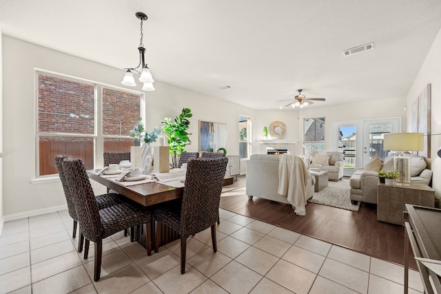 dining room with ceiling fan with notable chandelier and light tile patterned floors