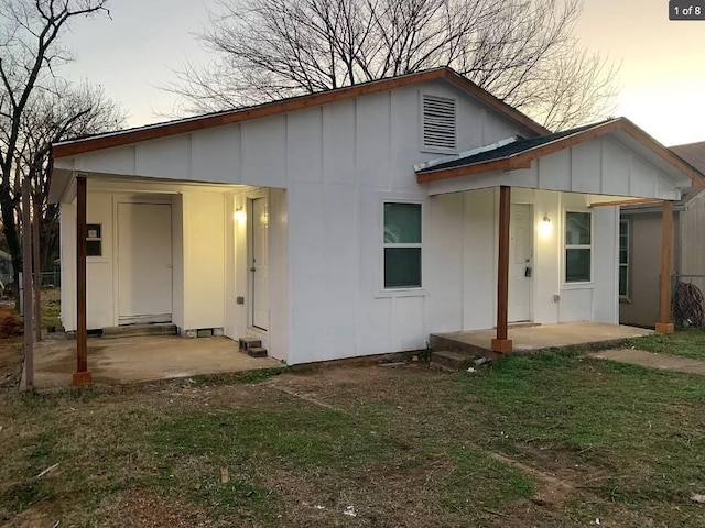 back house at dusk with a patio area