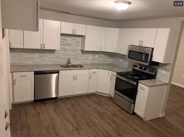 kitchen featuring dark wood-type flooring, sink, white cabinets, and appliances with stainless steel finishes