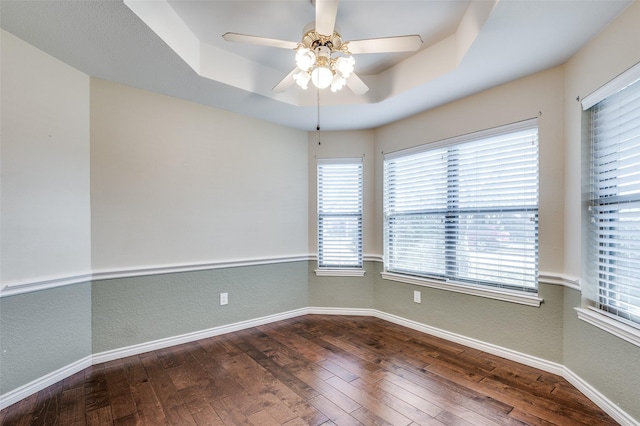 spare room featuring ceiling fan, hardwood / wood-style floors, and a tray ceiling