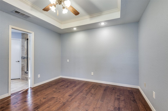 spare room featuring hardwood / wood-style floors, crown molding, and a raised ceiling