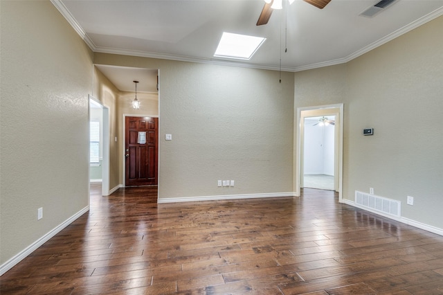 unfurnished room featuring ceiling fan, a skylight, dark hardwood / wood-style flooring, and ornamental molding