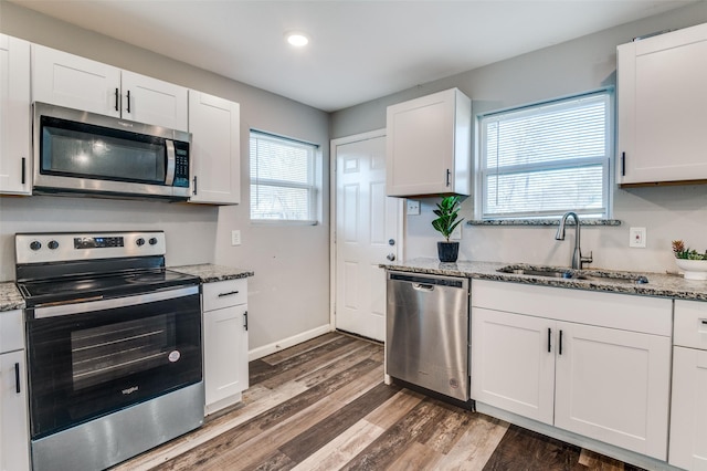 kitchen with sink, white cabinets, stainless steel appliances, and stone counters