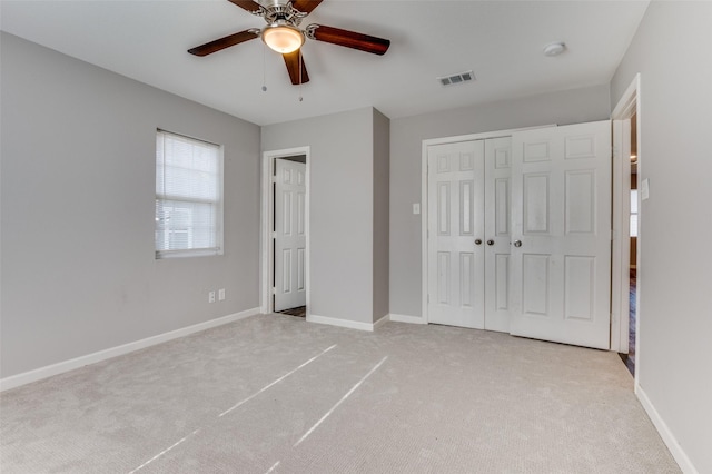 unfurnished bedroom with ceiling fan, a closet, and light colored carpet