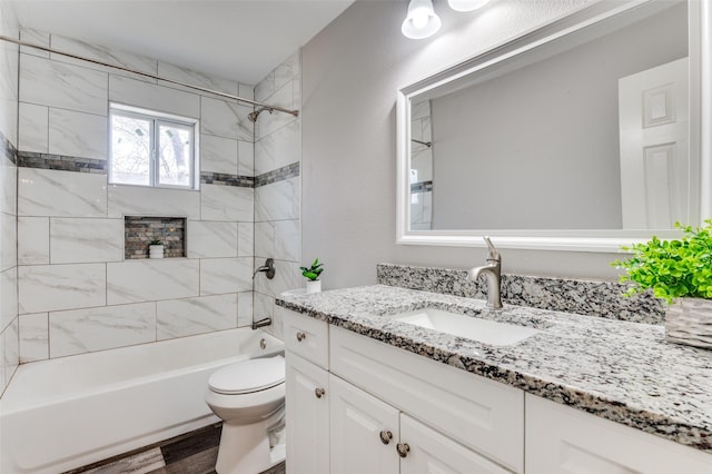 full bathroom featuring toilet, tiled shower / bath combo, wood-type flooring, and vanity