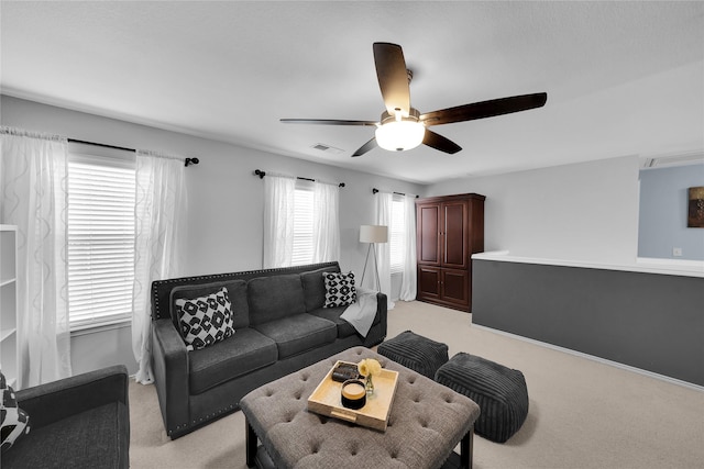 living room featuring plenty of natural light, light colored carpet, and ceiling fan