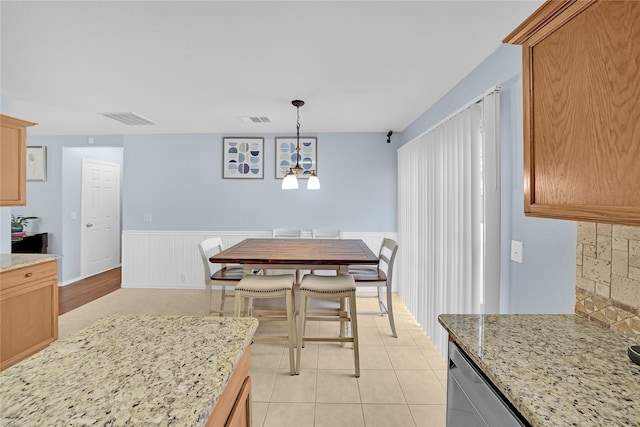 tiled dining room with a chandelier