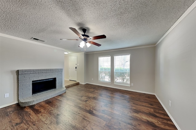 unfurnished living room with ceiling fan, a brick fireplace, ornamental molding, and dark wood-type flooring