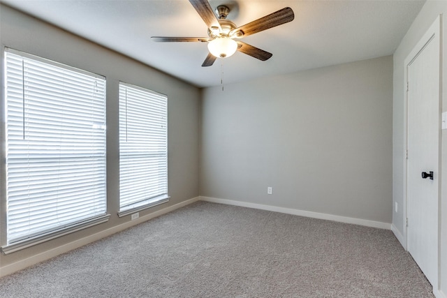 carpeted spare room with ceiling fan